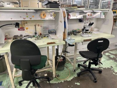deux bureaux avec des chaises et une planche de surf posée dessus