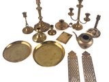 des bougeoirs en laiton, des plateaux et d’autres objets posés sur une surface blanche