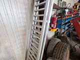 une échelle appuyée contre un mur, à côté d'un tas de pneus