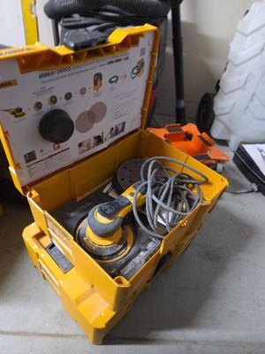 une boîte à outils jaune posée par terre, contenant des outils