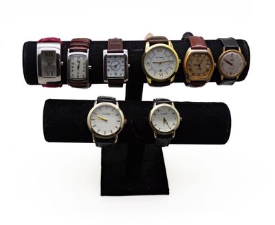 cinq montres exposées sur un présentoir noir