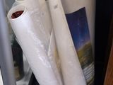 many rolls of white paper on the floor next to a refrigerator