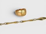 un gros plan d'une bague en or entourée d'une chaîne