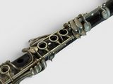 a close up of a silver and black clarinet on a white surface