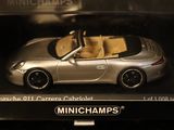 a silver toy car in a display case on a shelf