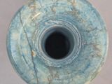 a blue vase that has a hole in the middle of it
