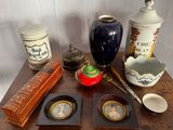 une table sur laquelle sont posés divers objets, notamment un vase, une théière et d'autres objets