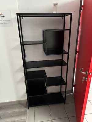 une porte rouge et une étagère noire dans une pièce