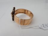 a close up of a gold bracelet with a tag on it
