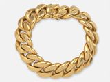 gros plan d'un bracelet en or sur fond blanc
