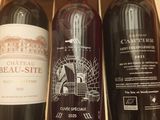 three bottles of wine in a wooden box on a table