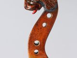 a close up of a violin neck with a dragon head on it