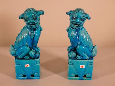pair of blue ceramic foo foo dogs sitting on a blue box