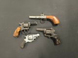 three old revolvers are sitting on a table with a black background
