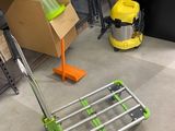 a cart with a green handle sitting on the floor next to a pile of boxes