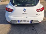 the rear end of a white car parked in front of a garage