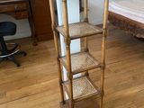a tall wooden shelf with a basket on top of it