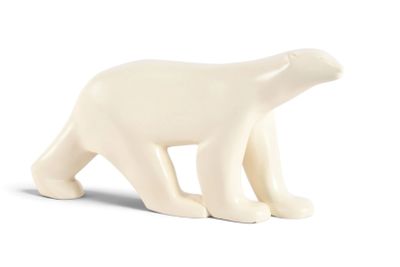 une petite figurine d'ours polaire blanc posée sur une surface blanche