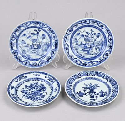 un service de quatre assiettes bleues et blanches ornées de motifs