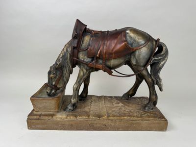 statue d'un cheval avec une selle sur le dos, posée sur un socle en bois