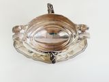 an antique silver plate with a handle on a white background