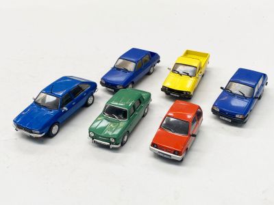 plusieurs petites voitures sont alignées sur une surface blanche