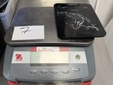 une balance numérique sur laquelle est posée une tablette