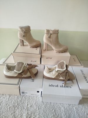 Plusieurs cartons de chaussures sont empilés les uns sur les autres sur un lit
