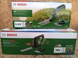 two bosch hedge trimers are sitting on a table in front of a cardboard box