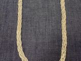 un collier en corde tressée sur fond gris