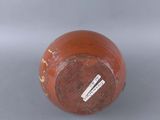 a brown vase with a tag on it sitting on a table