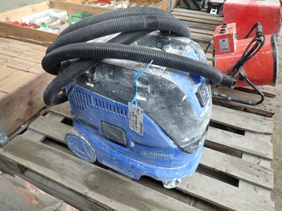 a blue vacuum sitting on a pallet next to other items