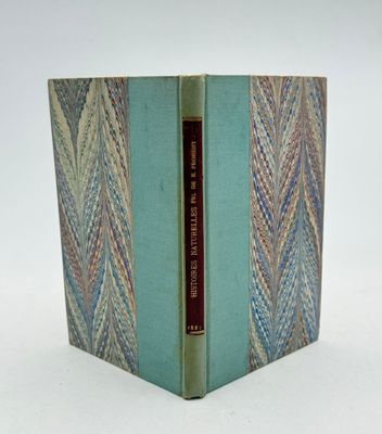 un vieux livre à la couverture bleue posé sur une surface blanche