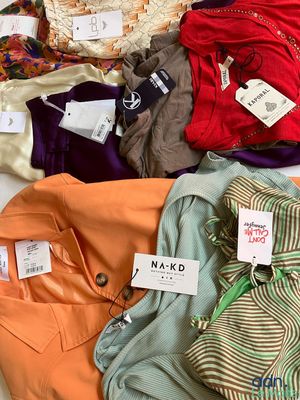a lot of clothes that are on a bed