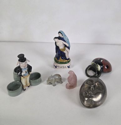several figurines of people and animals are displayed on a white surface