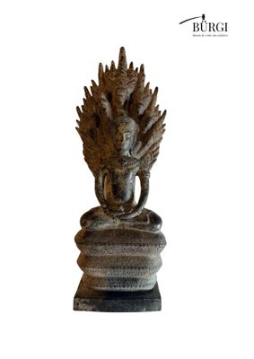 statue of a person sitting on a rock with a bird on his head