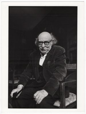 une vieille photo en noir et blanc d'un homme assis sur une chaise
