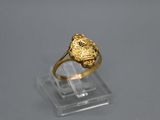 Gros plan sur une bague en or ornée d'une fleur