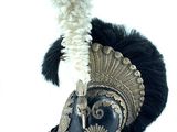 a helmet with a feather on top of it on a white surface