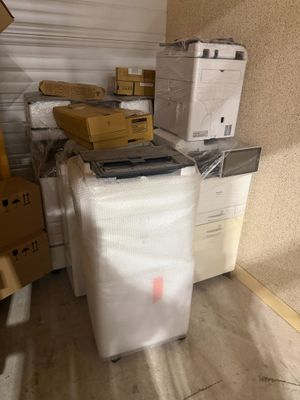 une pile de cartons et un ordinateur portable posés sur un chariot dans une pièce