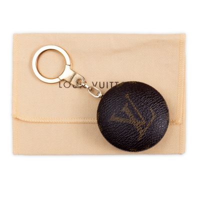 louis vuitt key chain with a black ball on a beige pouch
