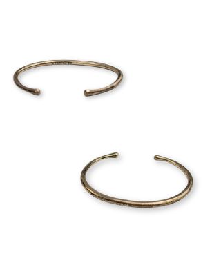 une paire de bracelets manchette en laiton sur fond blanc