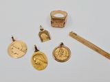 plusieurs bijoux en or, dont une bague, un stylo et une médaille