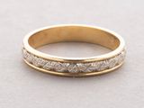 a close up of a gold wedding ring on a table