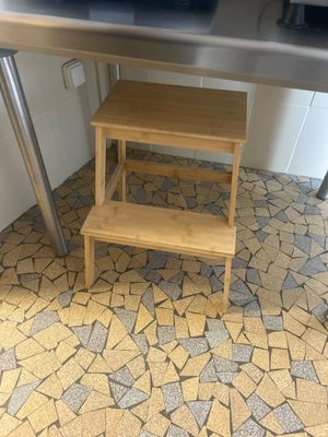 un tabouret en bois placé sous une table de cuisine
