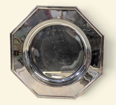 une plaque en argent sur laquelle est fixé un miroir, accrochée au mur