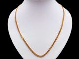 un collier en or autour du cou d'un mannequin, sur fond noir