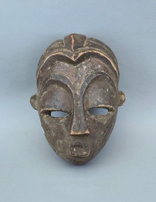gros plan d'un masque en bois sur une surface blanche