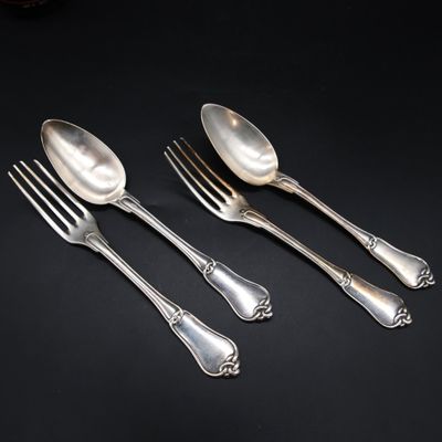 three silver spoons and a fork on a black surface