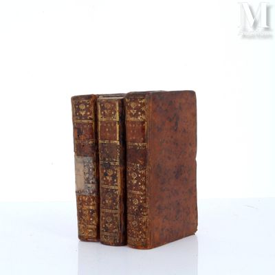 two old books sitting on top of each other on a white surface